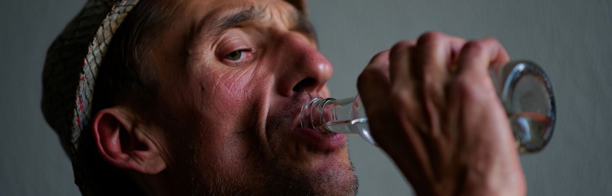 Мужчина с длительной зависимостью пьет алкоголь